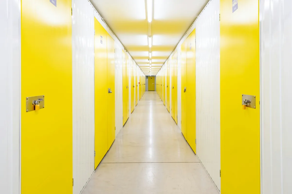 Indoor storage corridor lined with yellow unit doors