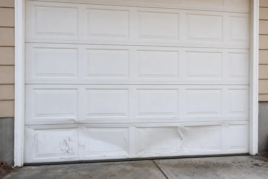 Dented panel sections on an older garage door in Springfield, MO