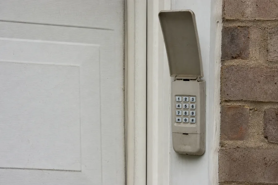 Keypad beside a garage door on a humid afternoon