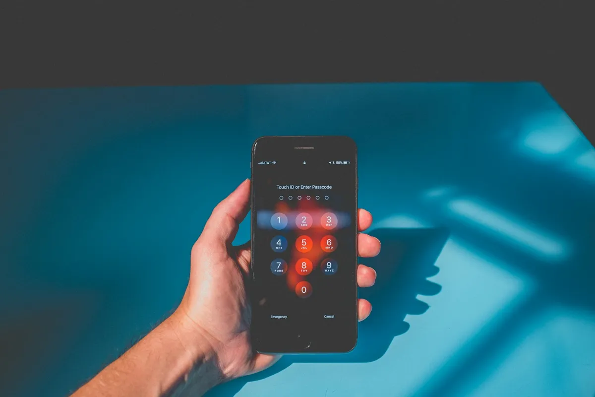 Hand holding a phone with a keypad screen